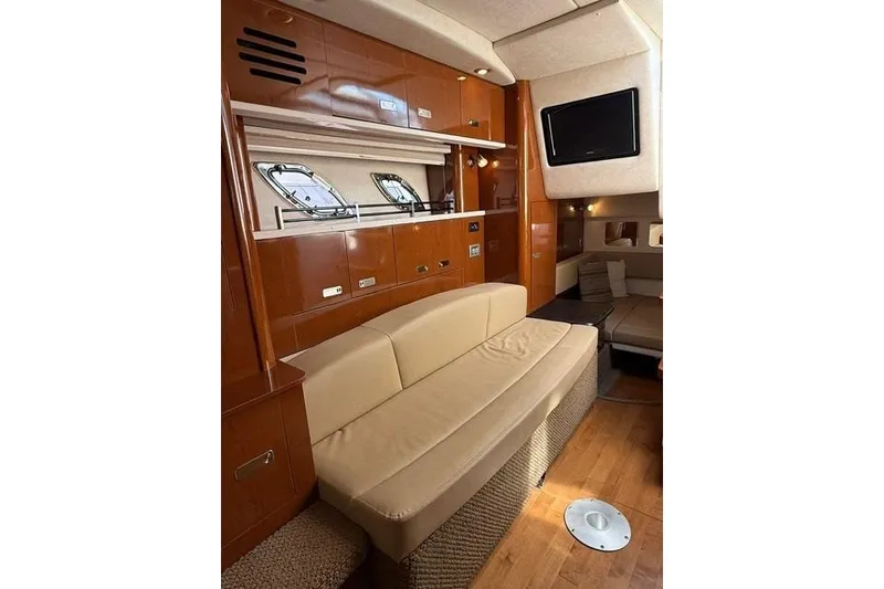 Slide: The Image of Interior of 2012 Sea Ray 330 Sundancer yacht with beige seating and wood cabinetry. - 21