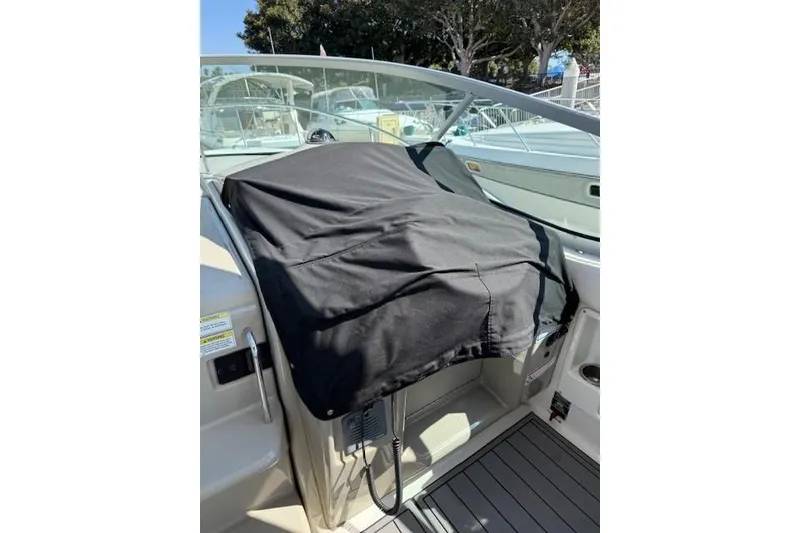 Slide: The Image of 2012 Sea Ray 330 Sundancer cockpit with black cover, docked at marina. - 32