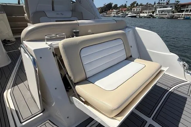 Slide: The Image of 2012 Sea Ray 330 Sundancer boat with beige and white seating, docked by waterfront homes. - 7