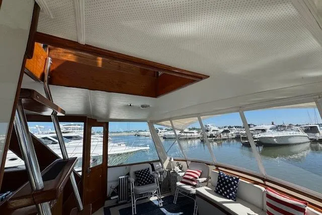 Slide: The Image of 1974 Chris-Craft 47 Commander interior with marina view, featuring seating and nautical decor. - 10