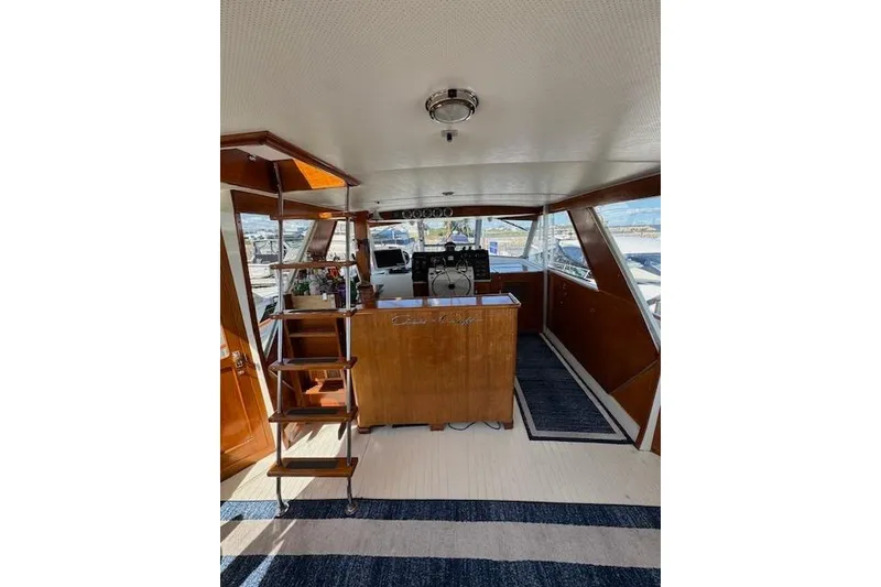 Slide: The Image of 1974 Chris-Craft 47 Commander interior with wooden helm and nautical decor. - 19