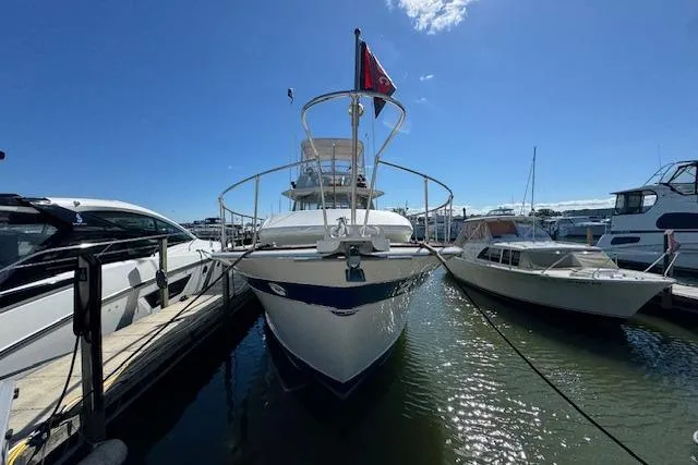 Slide: The Image of 1974 Chris-Craft 47 Commander yacht docked at marina under clear blue sky. - 2
