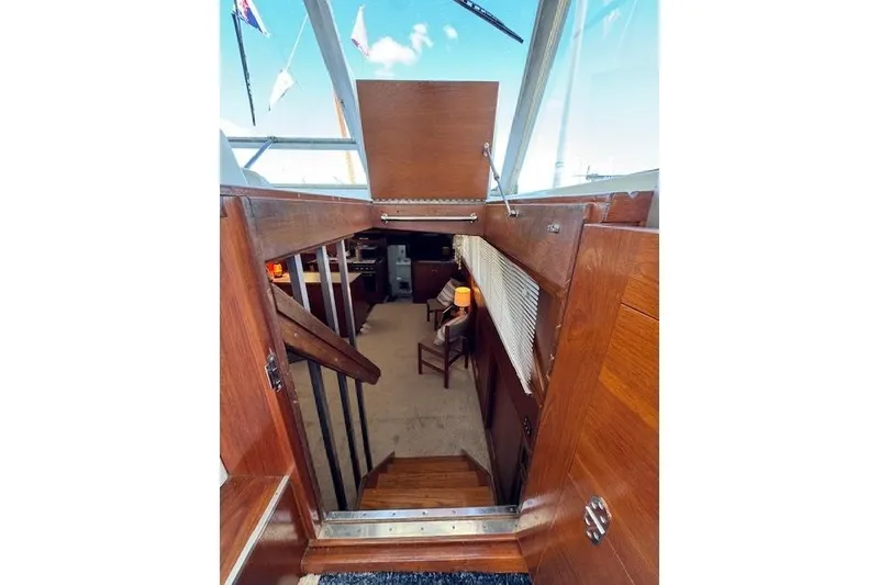 Slide: The Image of Interior view of 1974 Chris-Craft 47 Commander yacht, featuring wooden stairs and cozy cabin. - 23