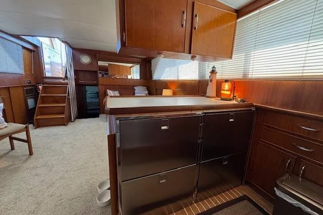 Slide: The Image of 1974 Chris-Craft 47 Commander interior with wood cabinetry and carpeted flooring. - 29