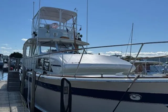 Slide: The Image of 1974 Chris-Craft 47 Commander yacht docked at marina under clear blue sky. - 3