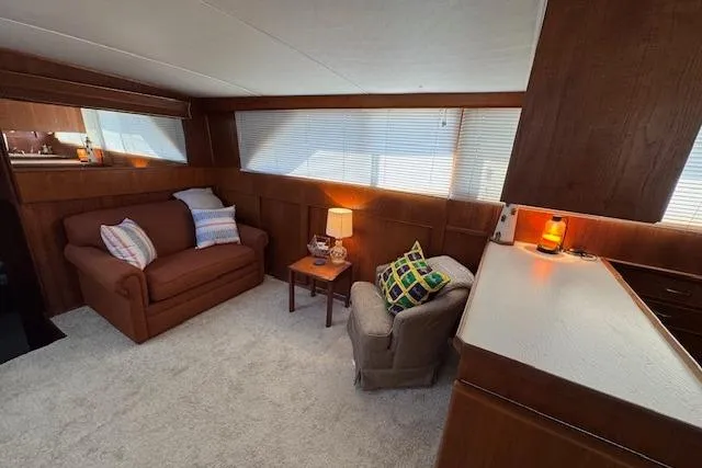 Slide: The Image of 1974 Chris-Craft 47 Commander interior with cozy seating and warm wood paneling. - 30
