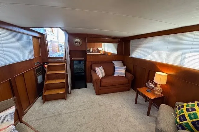 Slide: The Image of 1974 Chris-Craft 47 Commander interior with cozy seating, wooden paneling, and soft lighting. - 31