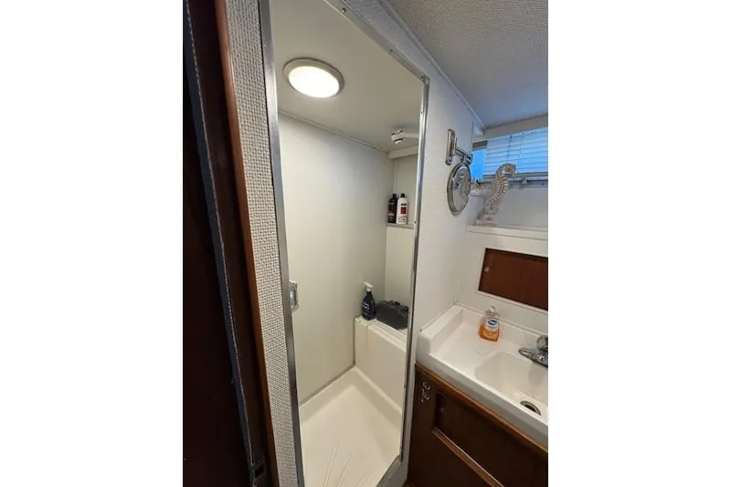 Slide: The Image of 1974 Chris-Craft 47 Commander bathroom with shower, sink, and storage. - 33