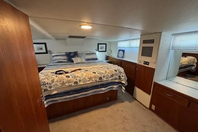 Slide: The Image of 1974 Chris-Craft 47 Commander bedroom with cozy bed, wood cabinetry, and nautical decor. - 34