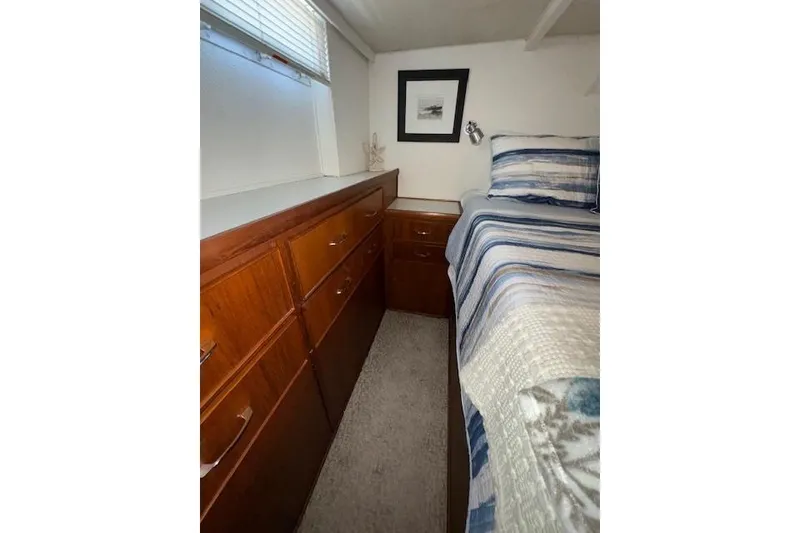 Slide: The Image of 1974 Chris-Craft 47 Commander cabin interior with wood cabinetry and striped bedding. - 37