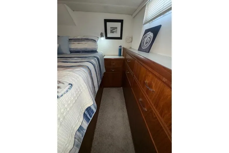Slide: The Image of 1974 Chris-Craft 47 Commander bedroom with wood cabinetry and striped bedding. - 38