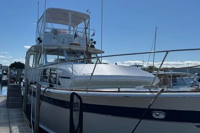 Slide: The Image of 1974 Chris-Craft 47 Commander yacht docked at marina under clear blue sky. - 4