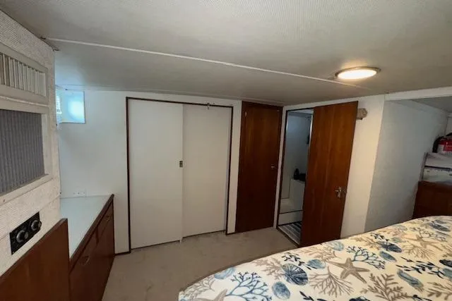 Slide: The Image of 1974 Chris-Craft 47 Commander interior cabin with bed, wooden doors, and storage. - 40