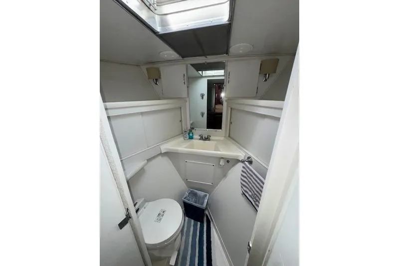 Slide: The Image of 1974 Chris-Craft 47 Commander bathroom with sink, toilet, and striped rug. - 42