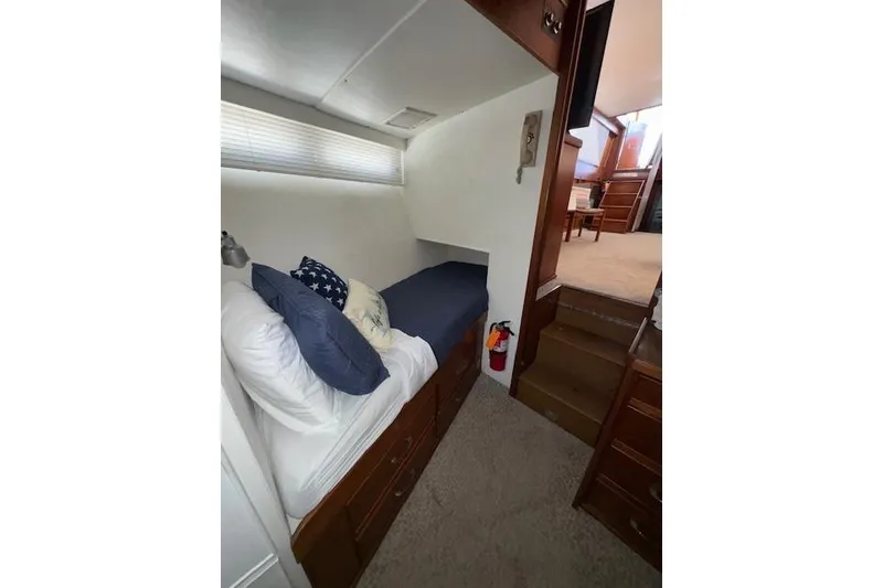 Slide: The Image of 1974 Chris-Craft 47 Commander cabin interior with bed, pillows, and wooden furnishings. - 44