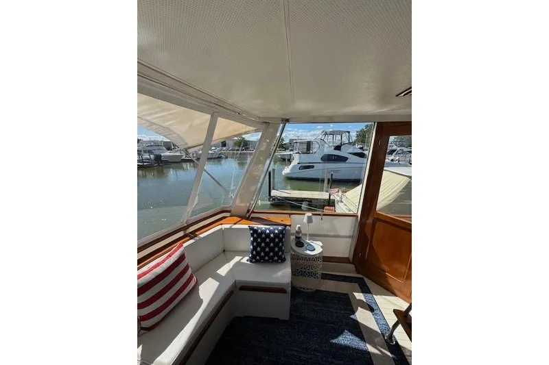 Slide: The Image of 1974 Chris-Craft 47 Commander interior with nautical-themed cushions and marina view. - 7