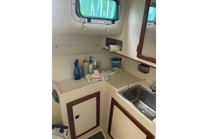 Slide: The Image of 1995 Albin 28 Tournament Express boat deck with fishing rod holders and dock view. - 10