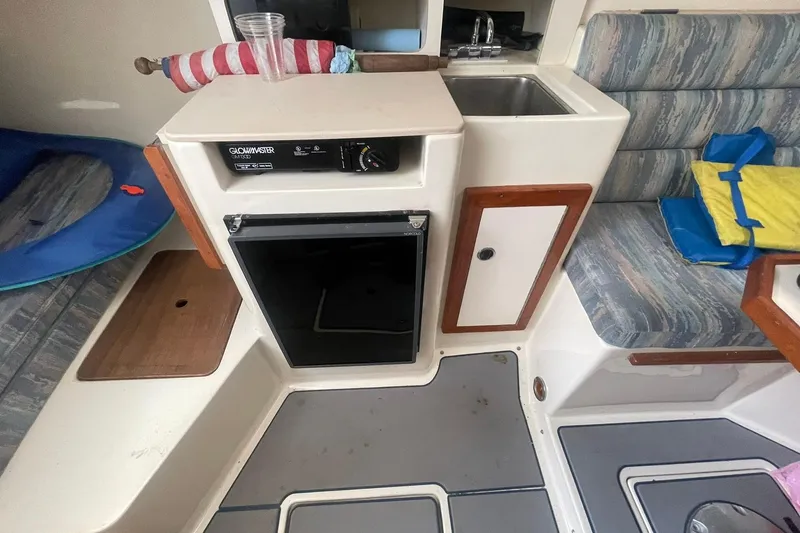 Slide: The Image of 1995 Albin 28 Tournament Express cockpit with steering wheel and control panel, overlooking water. - 11