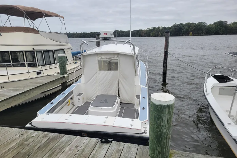 Slide: The Image of 1995 Albin 28 Tournament Express helm with steering wheel and control panel on a lake. - 14