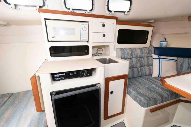 Slide: The Image of Interior of 1995 Albin 28 Tournament Express with kitchenette and seating area. - 19