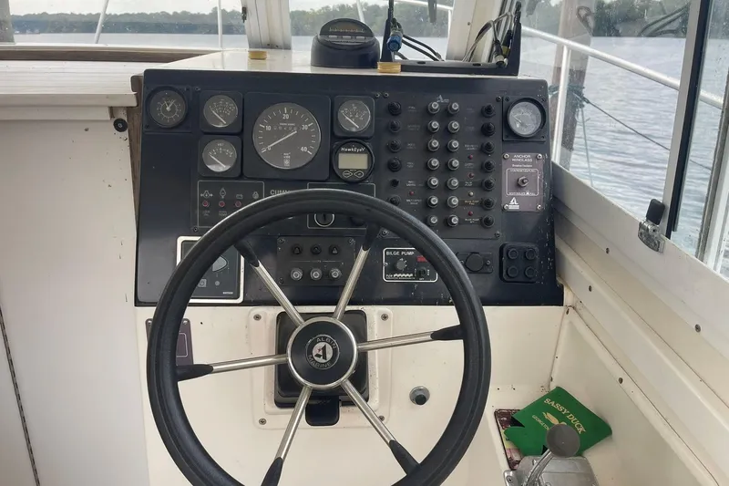 Slide: The Image of 1995 Albin 28 Tournament Express docked by a scenic waterfront under a partly cloudy sky. - 5