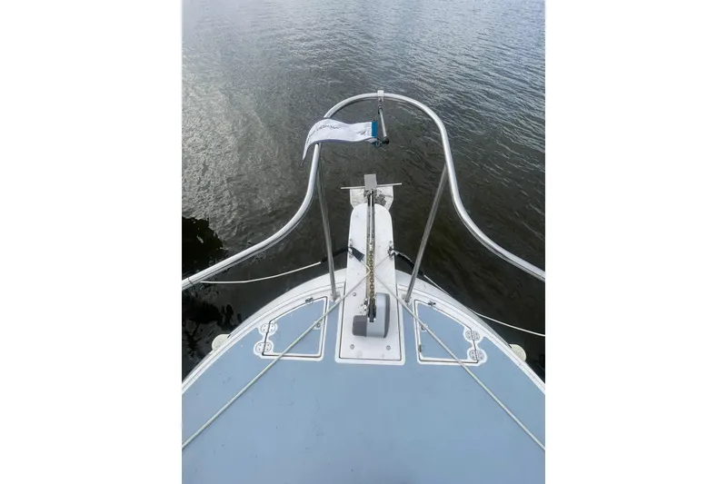 Slide: The Image of 1995 Albin 28 Tournament Express boat docked on a calm lake under a cloudy sky. - 8