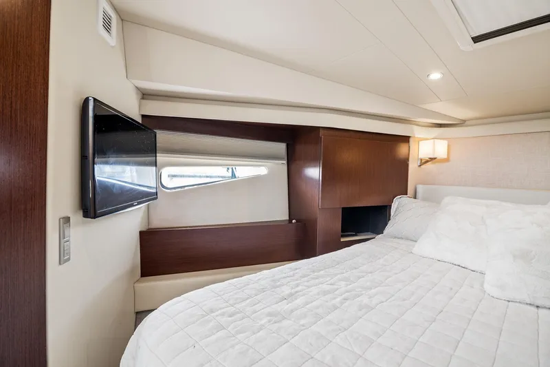 Slide: The Image of 2016 Regal 42 Grande Coupe yacht interior with seating and wooden table at marina. - 15