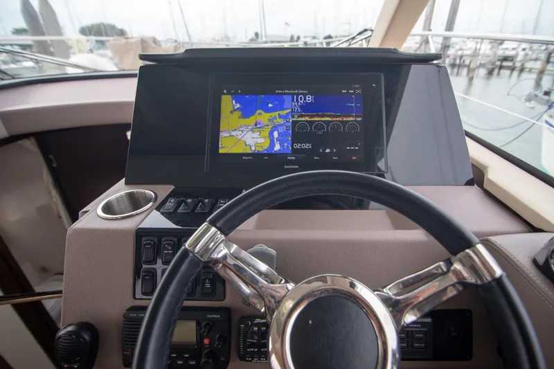 Slide: The Image of 2017 Regal 42 Grande Coupe yacht cruising in sunny waters near a modern marina. - 3