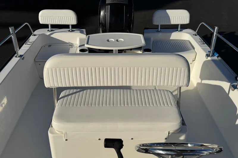 Slide: The Image of 2017 Boston Whaler 210 Montauk boat interior with white seating and steering wheel. - 11