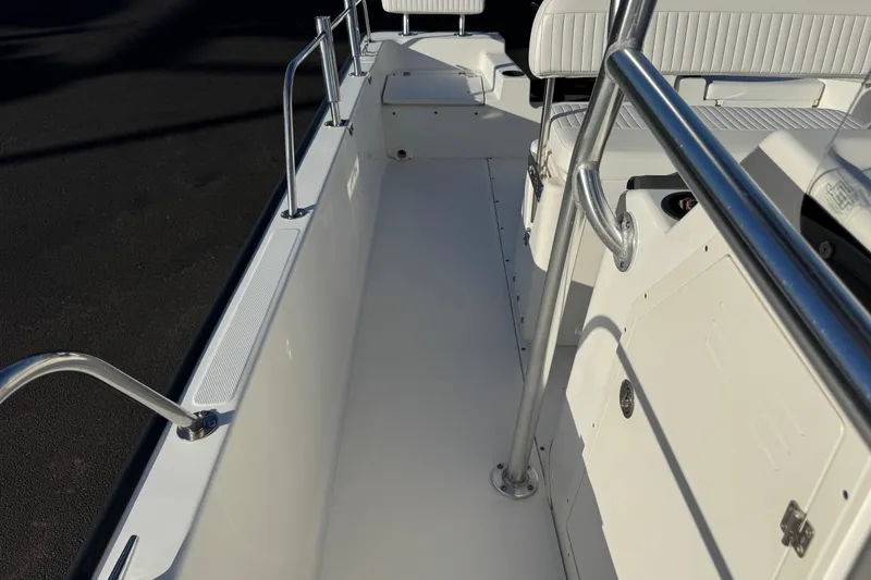 Slide: The Image of 2017 Boston Whaler 210 Montauk boat interior with white seating and stainless steel railings. - 16