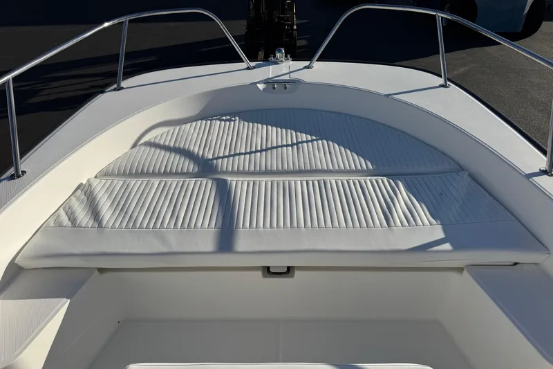 Slide: The Image of 2017 Boston Whaler 210 Montauk boat with cushioned seating area and stainless steel railings. - 9