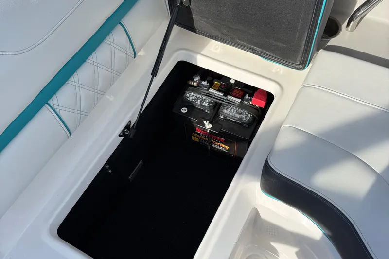 Slide: The Image of 2022 Regal LS2 boat battery compartment with seating and storage. - 10