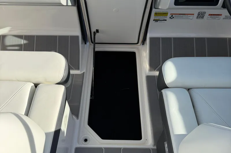 Slide: The Image of 2022 Regal LS2 boat interior with white seating and storage compartment. - 15