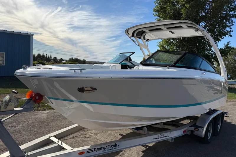 Slide: The Image of 2022 Regal LS2 boat on trailer, parked outdoors under a clear sky. - 2