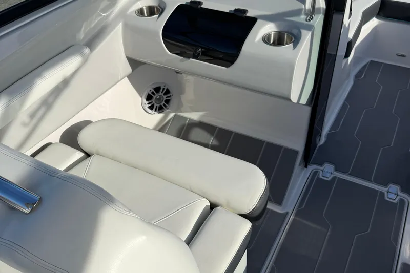 Slide: The Image of 2022 Regal LS2 boat interior with white seating, cup holders, and speaker. - 7