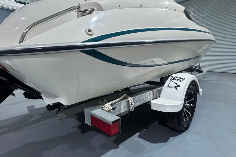 Slide: The Image of 1989 Glastron/Carlson 19 CSS boat on trailer, white with teal accents. - 3