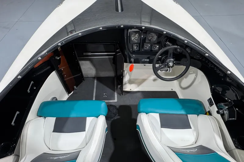 Slide: The Image of 1989 Glastron/Carlson 19 CSS boat interior with teal and white seats, steering wheel, and dashboard. - 5