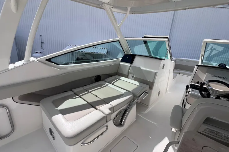 Slide: The Image of 2021 Boston Whaler 280 Vantage interior with seating and helm, featuring Garmin navigation. - 11