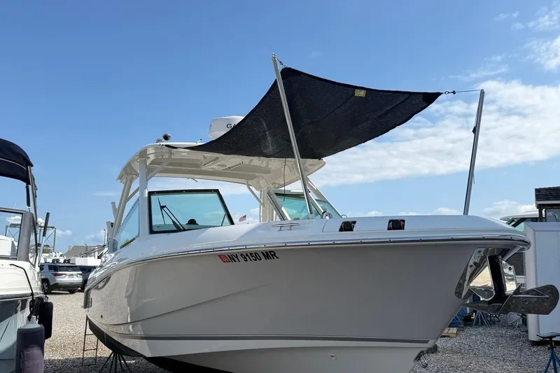 Slide: The Image of 2021 Boston Whaler 280 Vantage boat with canopy, docked under clear blue sky. - 20