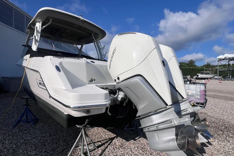 Slide: The Image of 2021 Boston Whaler 280 Vantage boat with dual Mercury outboard engines on a gravel lot. - 3