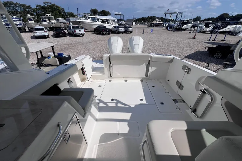 Slide: The Image of 2021 Boston Whaler 280 Vantage boat interior at marina, showcasing seating and storage. - 7
