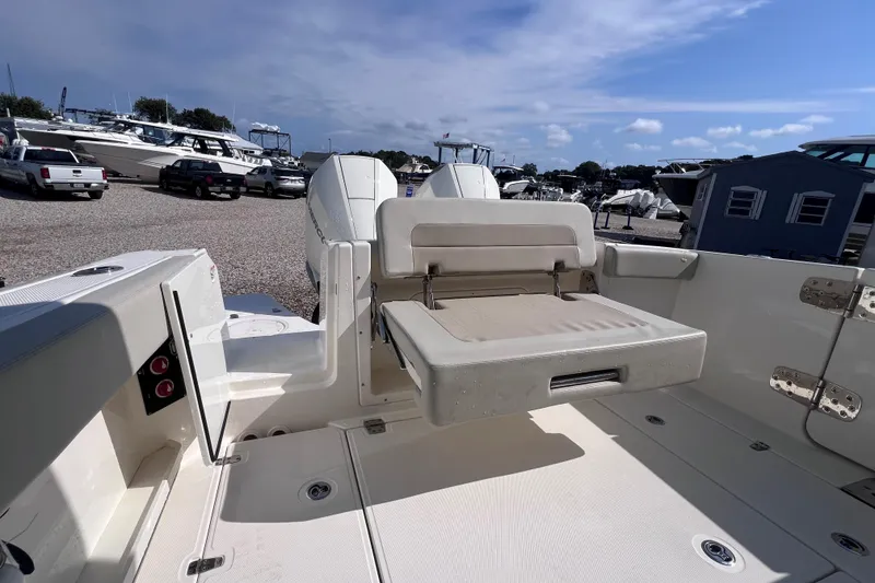 Slide: The Image of 2021 Boston Whaler 280 Vantage boat interior with seating, parked in a marina. - 8