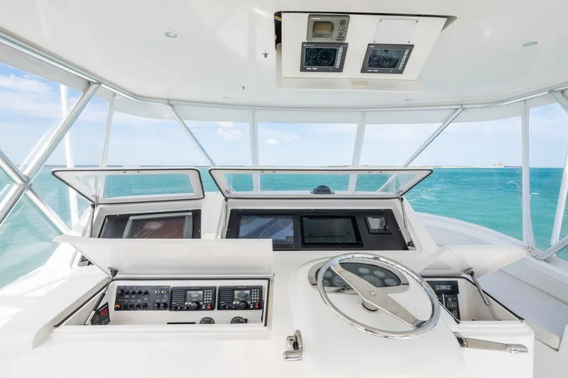 Slide: The Image of Helm of 2009 Viking 50 Convertible yacht with ocean view, featuring advanced navigation controls. - 6