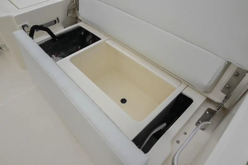 Slide: The Image of 2026 Pathfinder 2400 TRS boat storage compartment with cushioned seating and utility access. - 15