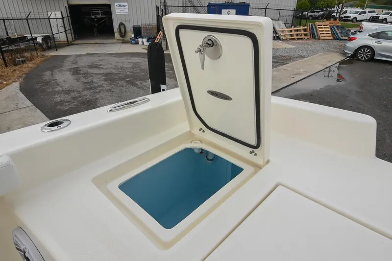 Slide: The Image of 2026 Pathfinder 2400 TRS boat with open storage compartment in a marina setting. - 17