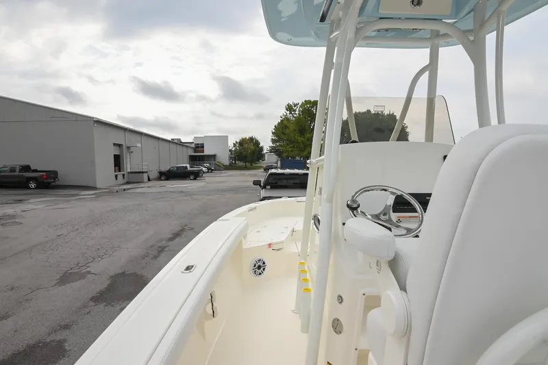 Slide: The Image of 2026 Pathfinder 2400 TRS boat interior with steering wheel, parked outdoors. - 22