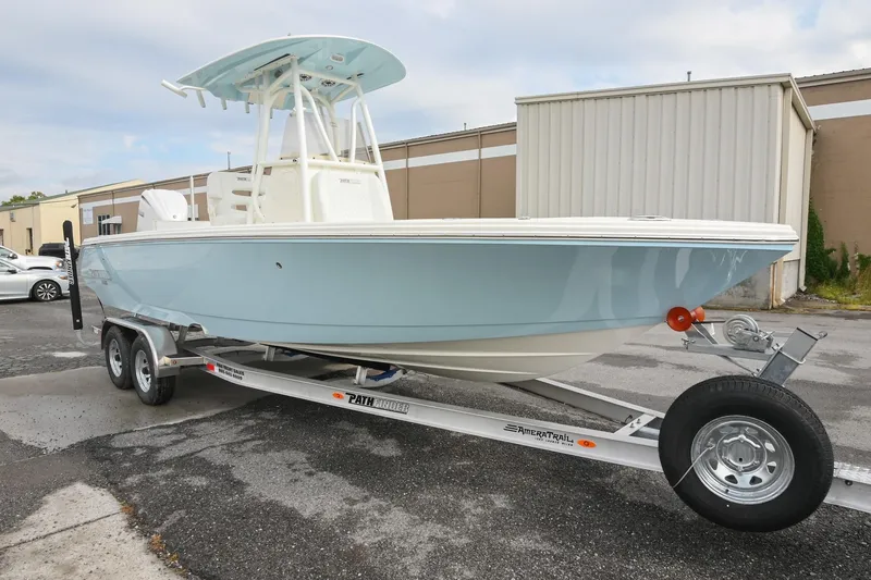 Slide: The Image of 2026 Pathfinder 2400 TRS boat on trailer, light blue hull, parked outdoors. - 4