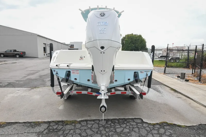Slide: The Image of 2026 Pathfinder 2400 TRS boat on trailer, rear view, in industrial area. - 9