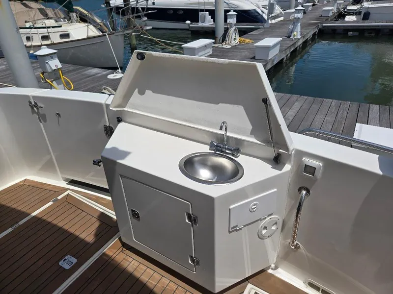 Slide: The Image of Outdoor seating area on 2010 American Tug 49 Limited yacht, featuring wicker chair and marina view. - 13