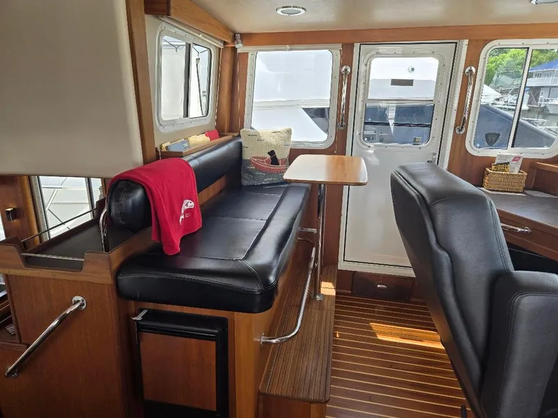 Slide: The Image of American Tug 49 Limited 2010 helm with navigation screens and marina view. - 27